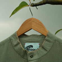 Load image into Gallery viewer, Moss Green full sleeve shirt with a brand collar on a wooden hanger against a light brown embroidery
