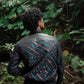 Person wearing a patterned jacket in a forest setting