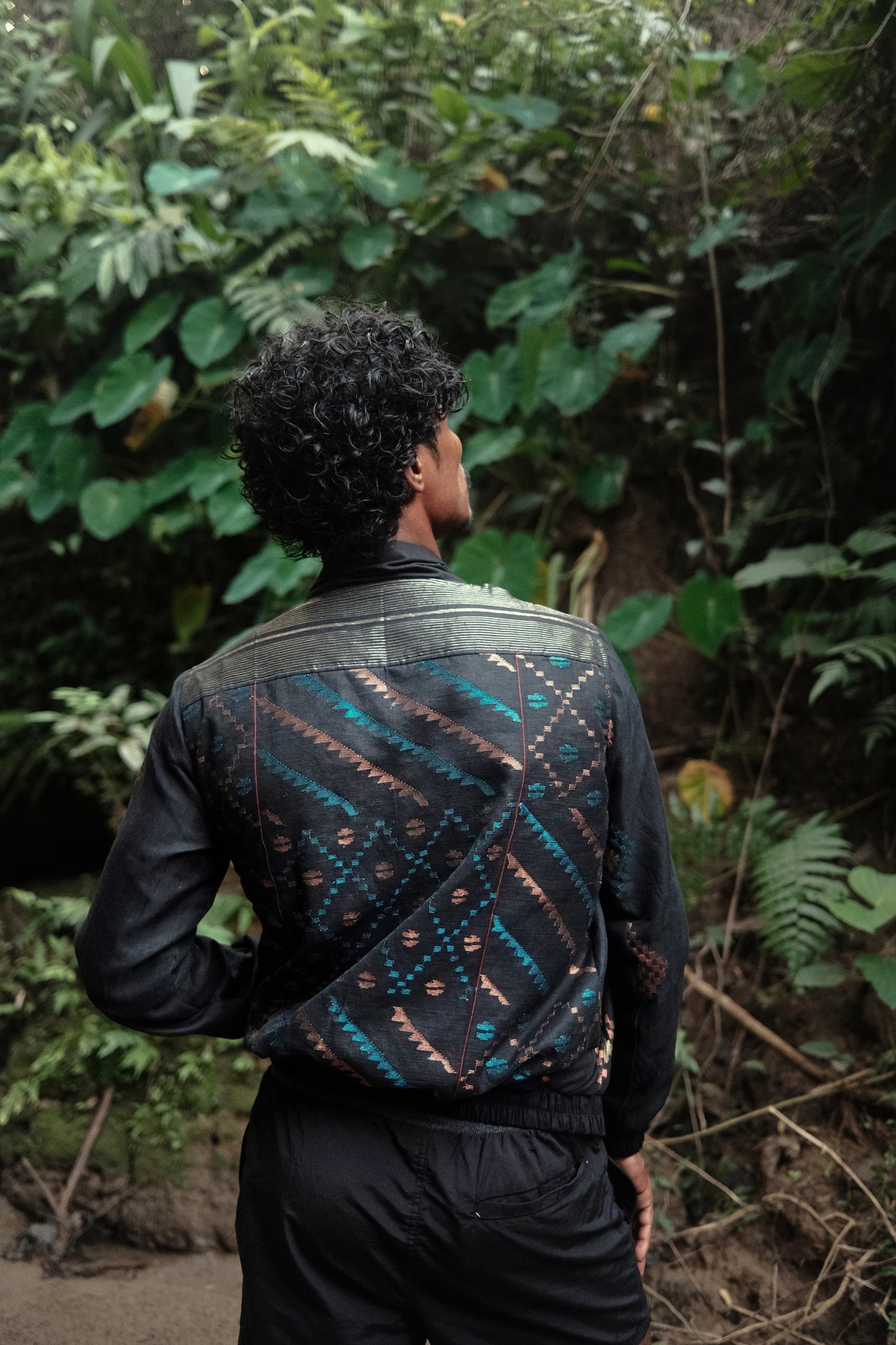 Person wearing a patterned jacket in a forest setting