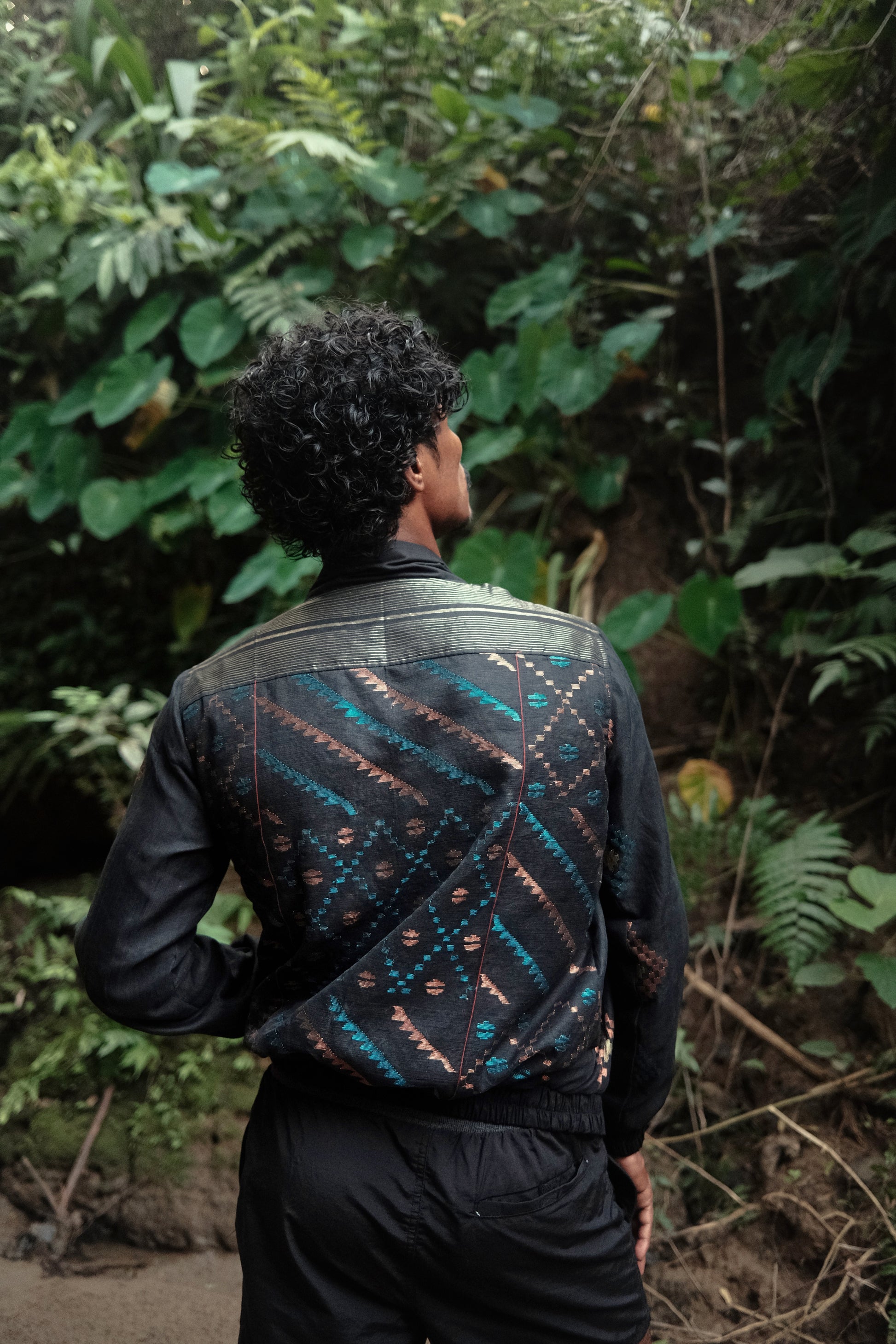 Person wearing a patterned jacket in a forest setting