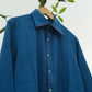 Blue shirt with red accents on a hanger against a white background