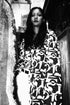 Person wearing a patterned dress sitting on a couch.