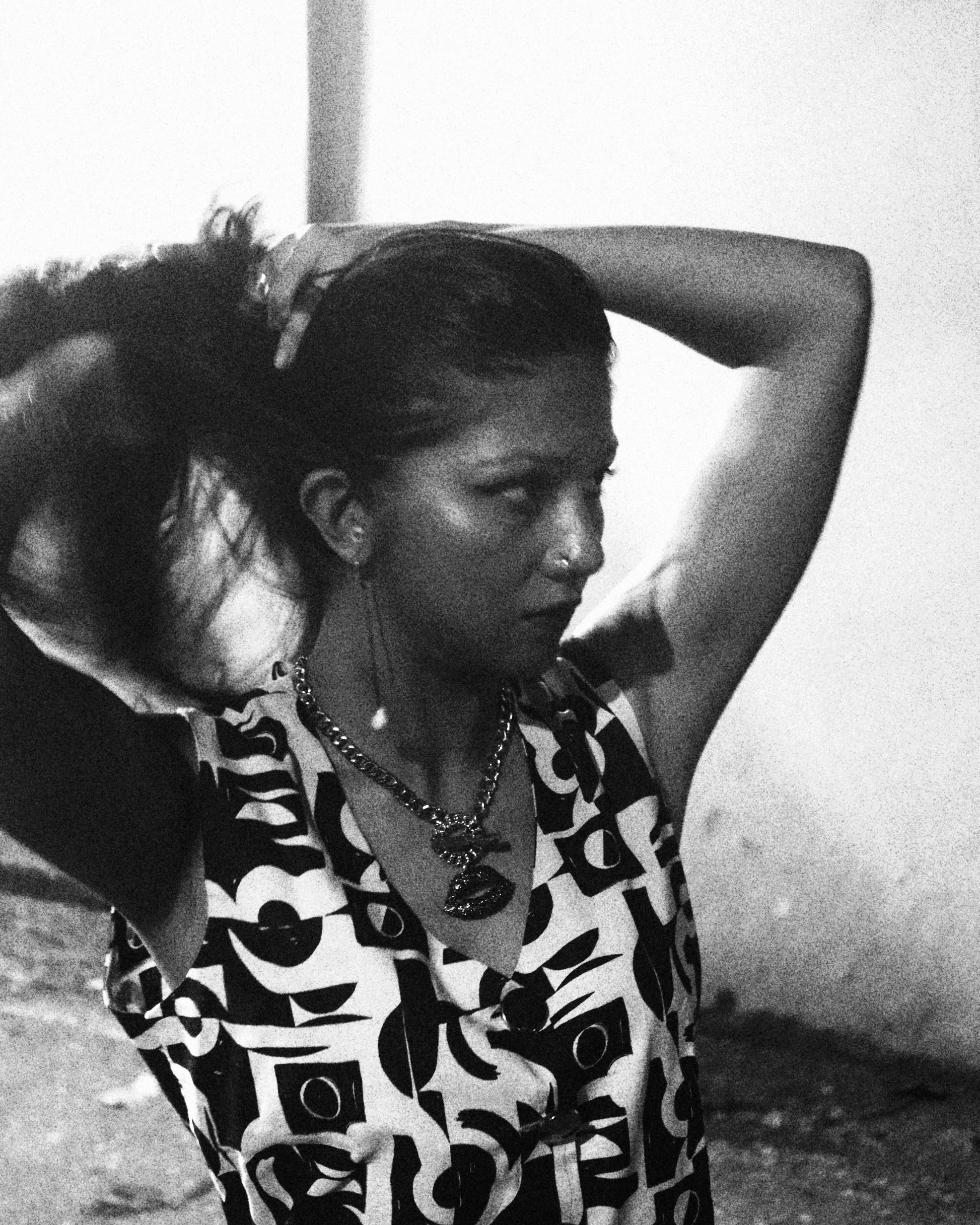 Black and white photo of a person wearing a patterned dress.
