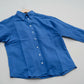 Blue shirt on a hanger against a grass background