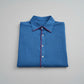 Folded blue shirt with red trim on a gray background