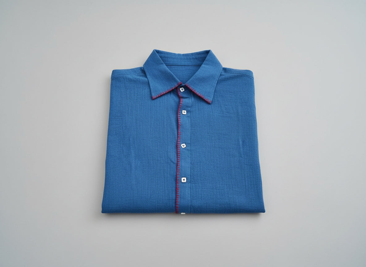 Folded blue shirt with red trim on a gray background