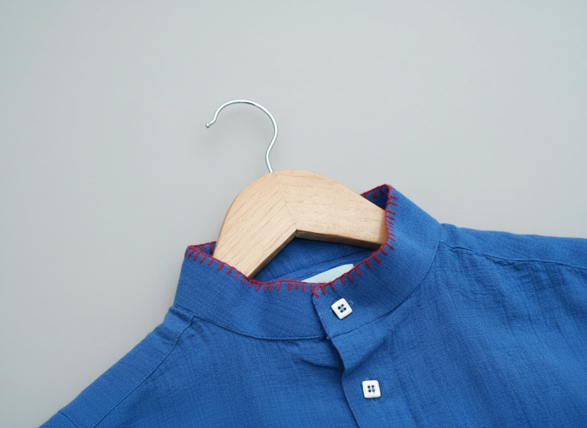 Blue shirt on a wooden hanger against a grass background